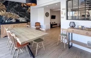 une cuisine et une salle à manger avec une table et des chaises en bois dans l'établissement Amazing Home In Cléder With Wifi, à Penar Pors