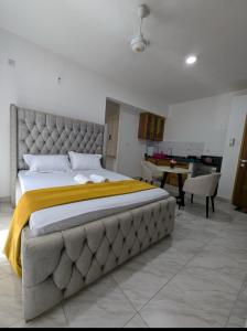 une chambre avec un grand lit et une table dans l'établissement Nancy's Haven studio apartment, à Mombasa 4 autres photos