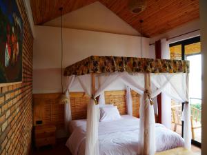 een slaapkamer met een hemelbed bij Muhazi Dolce Vita Ecolodge 