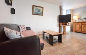 a living room with a couch and a tv at Charmante Maison Au Calme in Saint-Clément