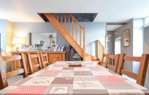 une salle à manger avec une table et un escalier dans l'établissement Charmante Maison Au Calme, à Saint-Clément