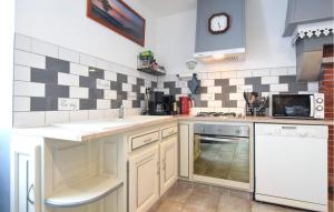 une cuisine avec des armoires blanches et du carrelage noir et blanc dans l'établissement Charmante Maison Au Calme, à Saint-Clément