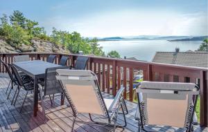 a table and chairs on a deck with a view of the water at Awesome Home In Nedstrand With Sauna in Vik +25 photos