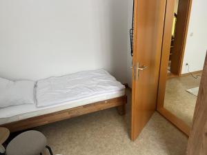 a small bedroom with a bed and a door at Ferienwohnung P5 in Schmölln