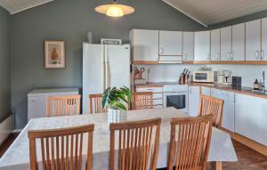a kitchen with a table with chairs and a refrigerator at Awesome Home In Nedstrand With Sauna in Vik
