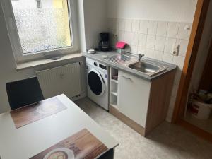 a small kitchen with a sink and a washing machine at Ferienwohnung P5 in Schmölln +1 photo