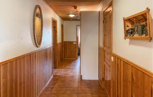 a hallway with wood paneled walls and a mirror at Lovely Home In Byxelkrok With Sauna in Byxelkrok