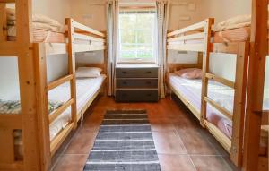 a room with three bunk beds and a window at Lovely Home In Byxelkrok With Sauna in Byxelkrok +5 photos