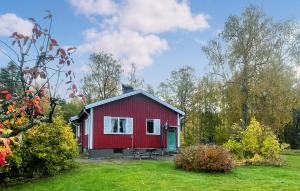a red house with a green door in a field at 2 Bedroom Awesome Home In Åmål in Torpane