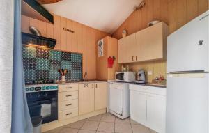 eine Küche mit weißen Geräten und Holzschränken in der Unterkunft Stunning Home In Eyraud-Crempse-Maurens in La Ressegue