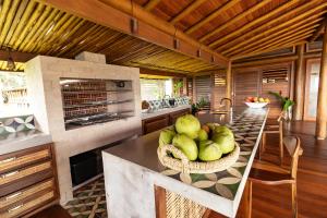 Una cocina con una mesa con un bol de fruta encima. en Jardim do Éden, en Ilhéus