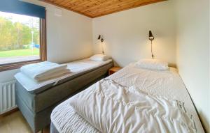 two twin beds in a room with a window at 2 Bedroom Amazing Home In Byxelkrok in Byxelkrok