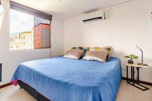 a bedroom with a blue bed with a window at City views Air-conditioning Heated pool in Envigado +74 photos