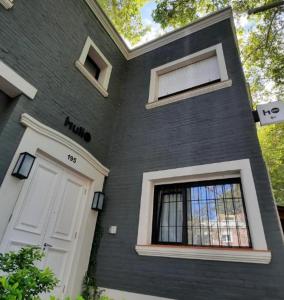 a black house with a white door and windows at Huli B&B in Mendoza