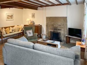 a living room with two couches and a fireplace at Jennys Cottage in Osmotherley