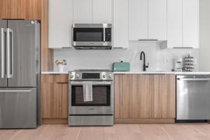 a kitchen with stainless steel appliances and wooden cabinets at Lux 2BD Apartment in Dupont Circle Washington DC in Washington +23 photos