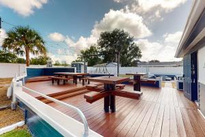 a deck with picnic tables and a swimming pool at Blue Boat House in Cocoa