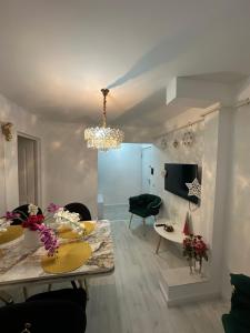 Una sala de estar con una mesa y una lámpara de araña. en Slatina Cornisiei apartament central 2 camere și living, en Slatina