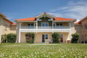 a house with an orange roof and a green yard at Résidence Indigo II - Ocean Plage Résidences in Biscarrosse-Plage