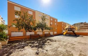 a building with benches and a playground in a courtyard at Stunning Apartment In Moncofa With Swimming Pool in Moncófar +14 photos