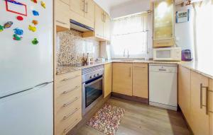 a kitchen with wooden cabinets and a white refrigerator at Stunning Apartment In Moncofa With Swimming Pool in Moncófar