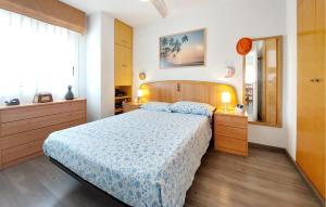 a bedroom with a bed with a blue and white bedspread at Stunning Apartment In Moncofa With Swimming Pool in Moncófar