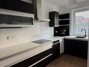 a kitchen with white and black cabinets and a window at Vila Linet in Poprad