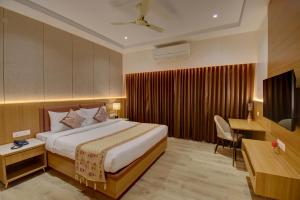 a hotel room with a bed and a desk at Hotel Warma Palace in Yeola +52 photos