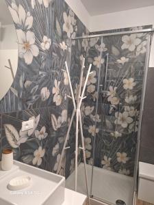 a bathroom with a floral patterned wall at LGO Apartments in Portocannone