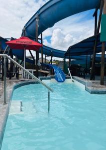 a pool with a water slide and an umbrella at Genoeg in Langebaan