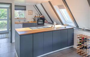 a kitchen with blue cabinets and a counter top at 2 Bedroom Nice Home In Humble in Ristinge