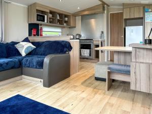 een woonkamer met een blauwe bank in een keuken bij Arran View Craig Tara in Ayr