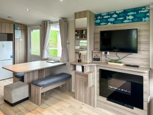 een keuken met een bureau, een tv en een open haard bij Arran View Craig Tara in Ayr