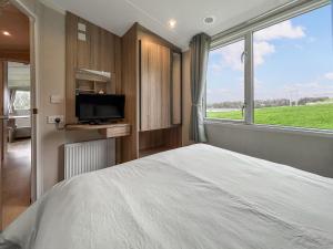 een slaapkamer met een bed, een tv en een raam bij Arran View Craig Tara in Ayr +7 foto's