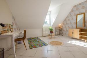 una habitación en el ático con un espejo, una mesa y sillas en Le charles augustin, en Lusigny-sur-Barse