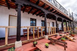 アンティグア・グアテマラにあるAmura Hostel - Antigua Guatemalaの木製のベンチ付きの家の出口