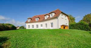 una casa grande en la cima de una colina con césped en Le charles augustin, en Lusigny-sur-Barse