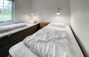 Gorgeous Home In Byxelkrok With Wifi في بيكسلكروك: سريرين توأم في غرفة بها نافذة