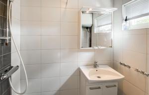 Gorgeous Home In Byxelkrok With Wifi في بيكسلكروك: حمام أبيض مع حوض ومرآة +4 صور