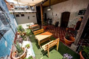 アンティグア・グアテマラにあるAmura Hostel - Antigua Guatemalaのパティオ(テーブル、ベンチ、鉢植えの植物付)