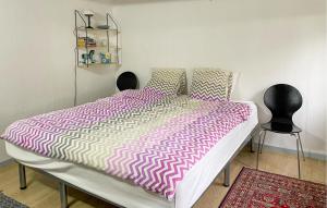 a bedroom with a bed with a pink and white comforter at 3 Bedroom Gorgeous Home In Søby Ærø in Soby Mark