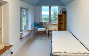 a bedroom with a bed and a chair and windows at 3 Bedroom Gorgeous Home In Søby Ærø in Soby Mark