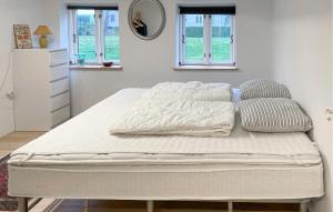 a bed with white sheets and pillows on it at 3 Bedroom Gorgeous Home In Søby Ærø in Soby Mark