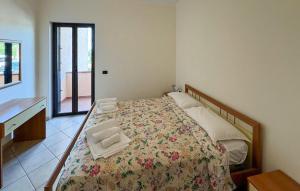 ein Schlafzimmer mit Bett, Schreibtisch und Fenster in der Unterkunft 1 Bedroom Cozy Apartment In Ricadi in San Nicolò