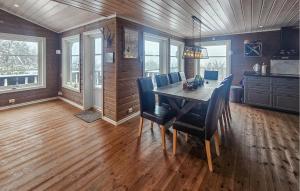 a dining room with a wooden table and chairs at Cozy Home In Ulnes With Sauna in Brujordet