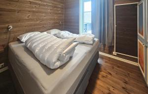 a bed with white pillows on it in a room at Cozy Home In Ulnes With Sauna in Brujordet +16 photos