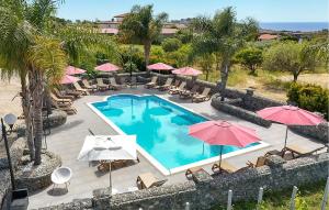 eine Draufsicht auf einen Swimmingpool mit Sonnenschirmen in der Unterkunft Lovely Apartment In Ricadi in San Nicolò