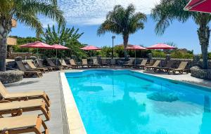 ein Swimmingpool mit Stühlen und Sonnenschirmen in der Unterkunft Lovely Apartment In Ricadi in San Nicolò + 10 Fotos