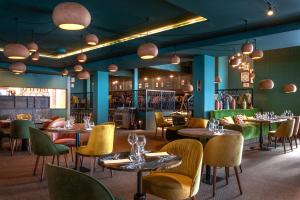 ラ・ロジエールにあるILY Hotels & Spa La Rosiereのテーブルと椅子と照明のあるダイニングルーム