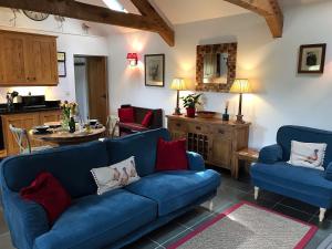 a living room with a blue couch and a table at The Barn, Llanerch Y Felin in Rowen